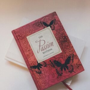 Red journal with floral and butterfly cover design against a soft background.